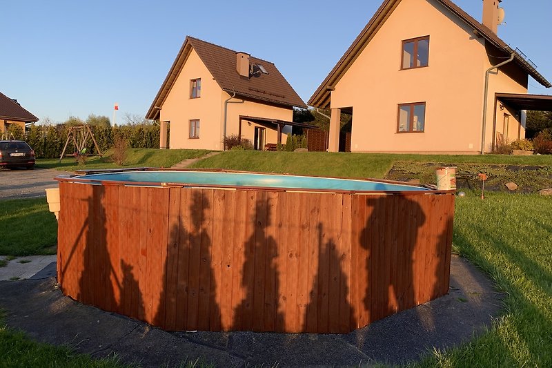 Gemütliches Haus mit Holzfassade, grünem Garten und malerischer Landschaft.