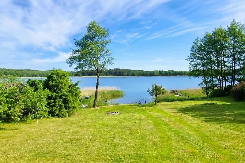 Blauer See mit grüner Ufervegetation und natürlicher Umgebung.
