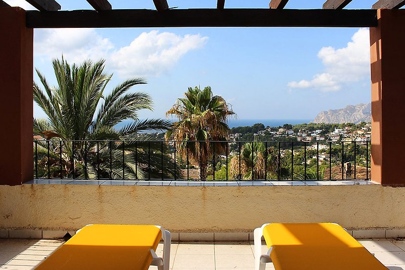 Schönes Ferienhaus mit Meerblick, Balkon und tropischer Umgebung.