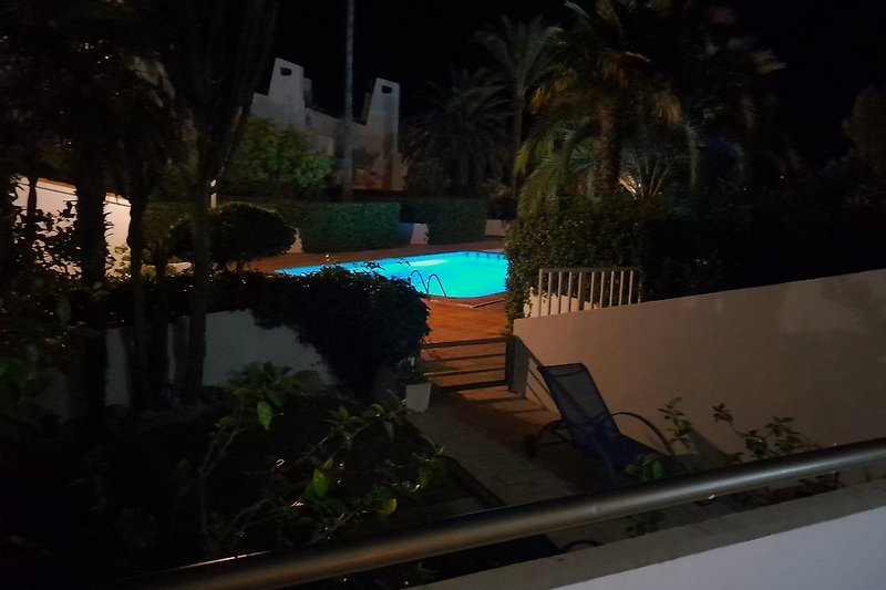 Blick von der Terrasse zum großem beleuchteten Pool