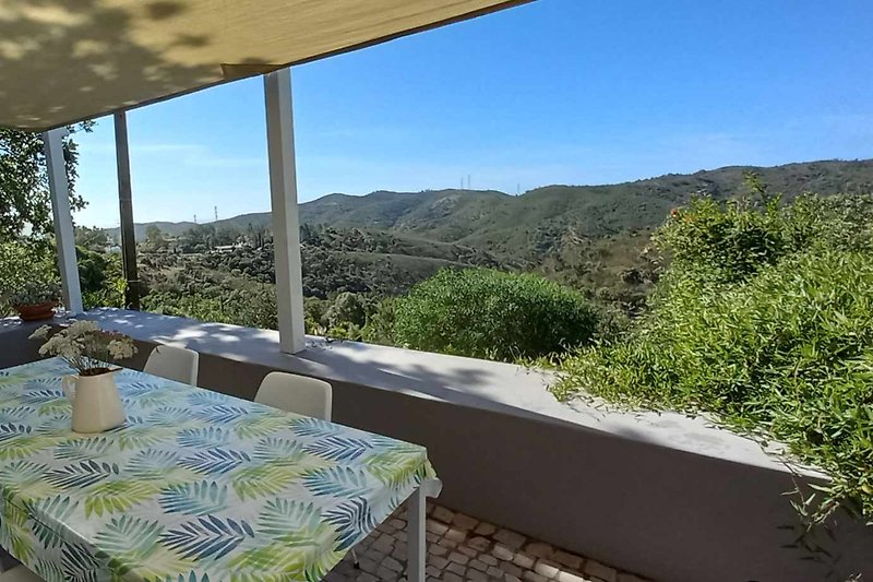 Geniet van het uitzicht op de bergen vanuit deze charmante cottage met een groene tuin en een ontspannend terras.