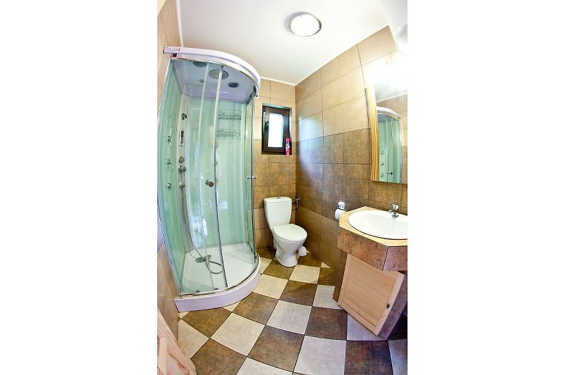 Das Badezimmer befindet sich im Erdgeschoss. Es ist modern mit einer Duschkabine, Waschbecken und WC ausgestattet.