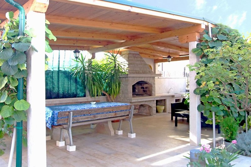 Covered terrace in garden with grill