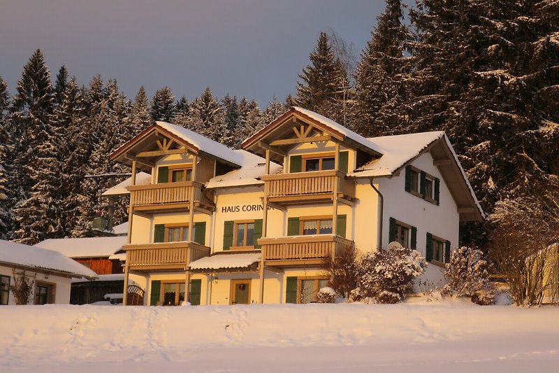 Gemütliches Ferienhaus mit verschneiter Landschaft und malerischem Ausblick.