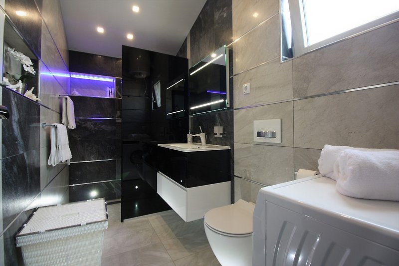 Luxuriöses und modernes Badezimmer mit Waschmaschine im ersten Stock