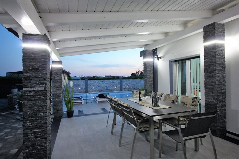 Outdoor terrace enjoys peaceful surrounding and view on the pool