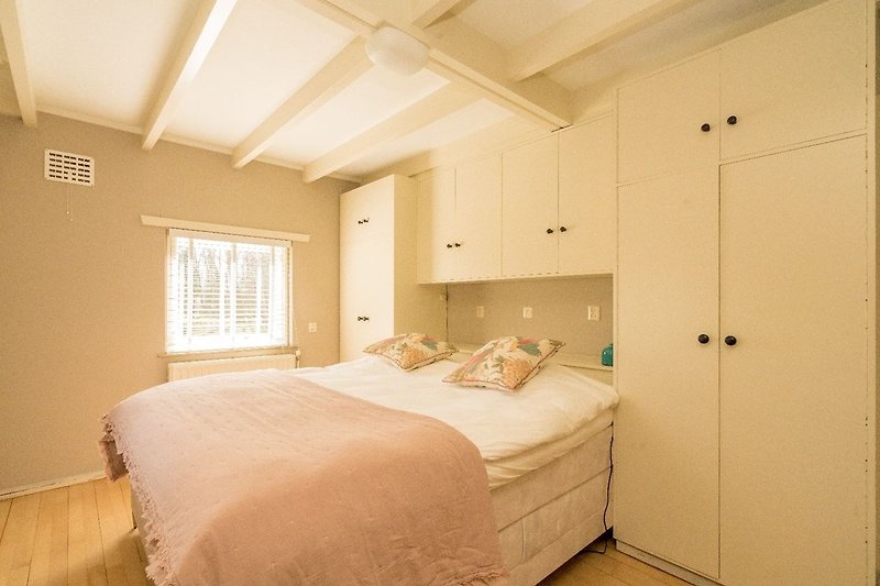 Schlafzimmer 1 mit Doppelbett, Schrank und Waschbecken
