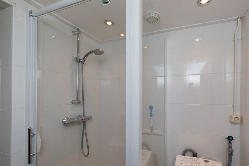 De moderne badkamer met douche, wastafel en toilet
