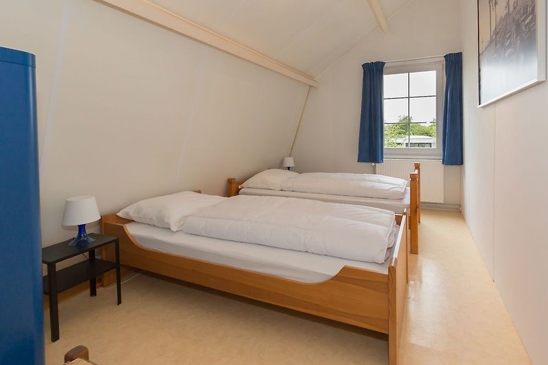 Chambre 3 avec 2 lits simples et une armoire