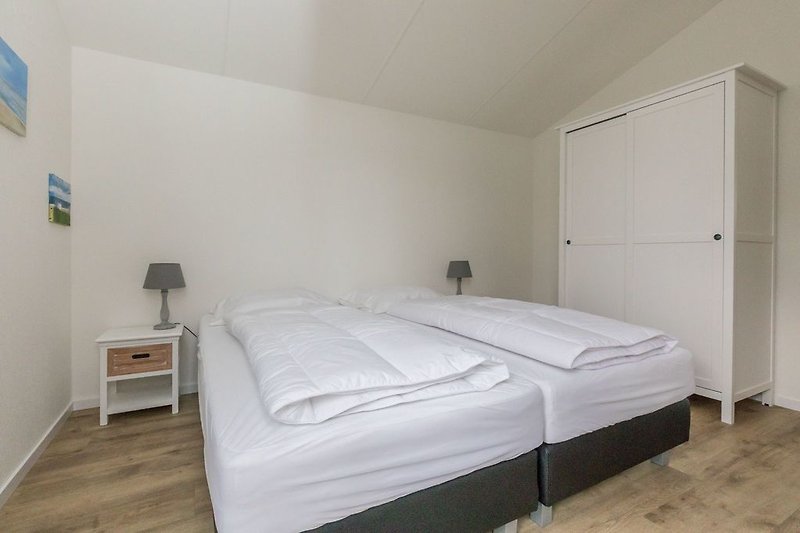Sypialnia 1 z łóżkami typu boxspring i szafą na ubrania