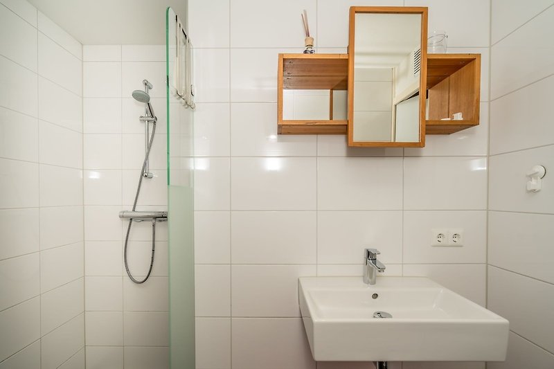 Bathroom with shower and bathroom furniture