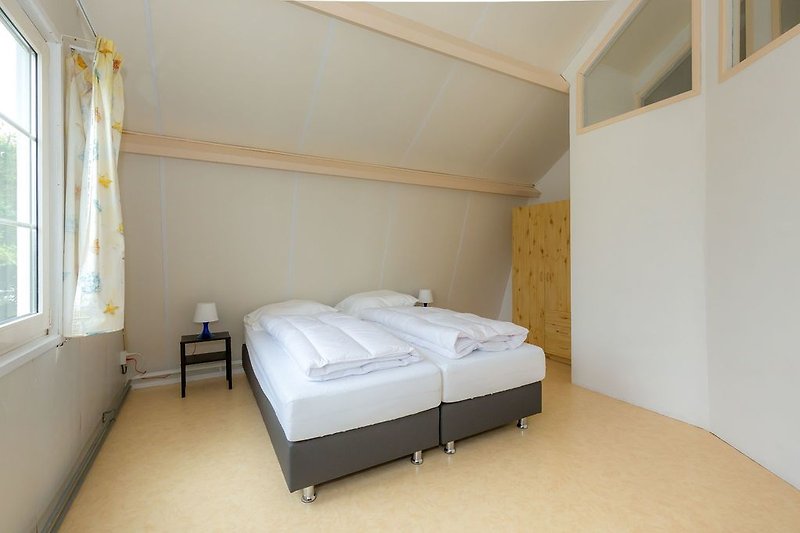 Slaapkamer 1 met 2 boxsprings, wastafel en kledingkast