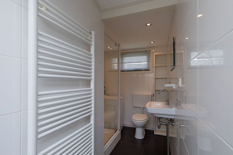 De moderne badkamer met douche, wastafel en toilet