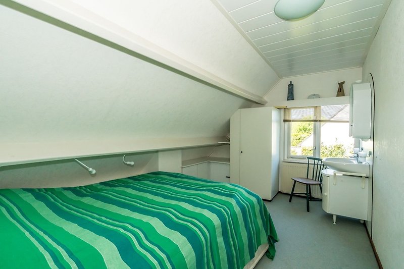 Sypialnia 3 na 1. piętrze z podwójnym łóżkiem i umywalką.