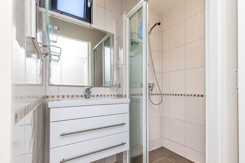 Badkamer met douche en badkamermeubel