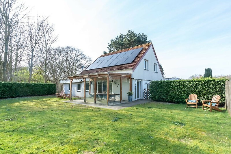 Ländliches Haus mit Garten und Wolken.