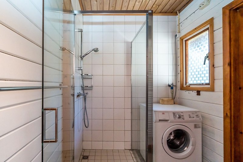 Badkamer met douche en wasmachine