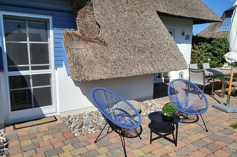 Ein idyllischer Garten mit Holzmöbeln und einem Sonnenschirm.