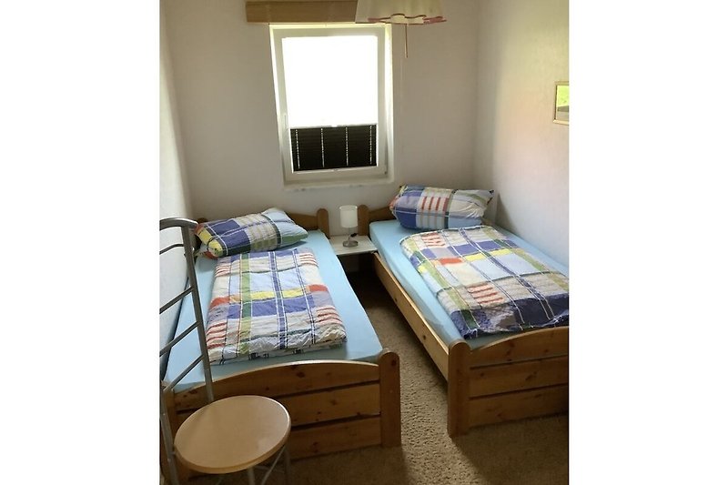 2 Schlafzimmer mit Betten und Kleiderschrank