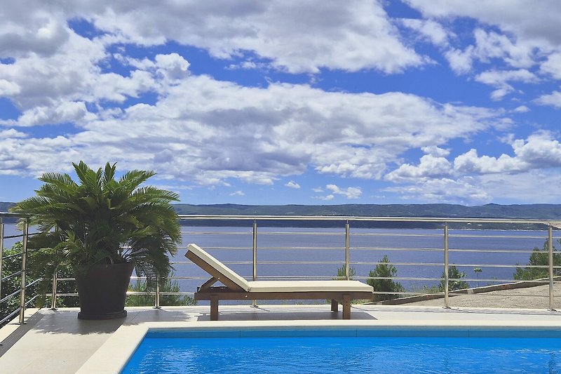 Tropische Villa mit Pool, Palmen und Meerblick.