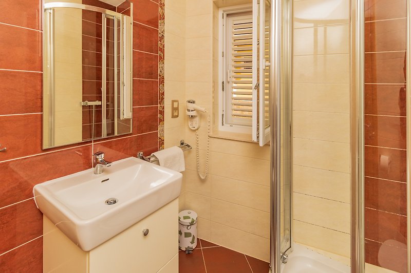 Ein modernes Badezimmer mit Spiegel, Waschbecken und Armatur.