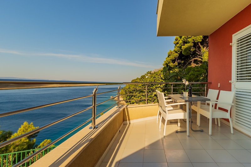Ein gemütlicher Balkon mit Blick auf den See und bequemen Gartenmöbeln.