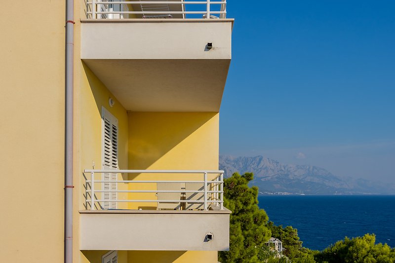Moderne Stadtwohnung mit Balkon, Blick auf Berge und Wasser.