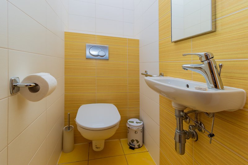 Badezimmer mit lila Wand, Spüle, Toilette und Wasserhahn.