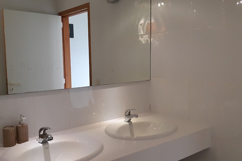 Bellissimo lavabo spazioso in un confortevole bagno completamente bianco.