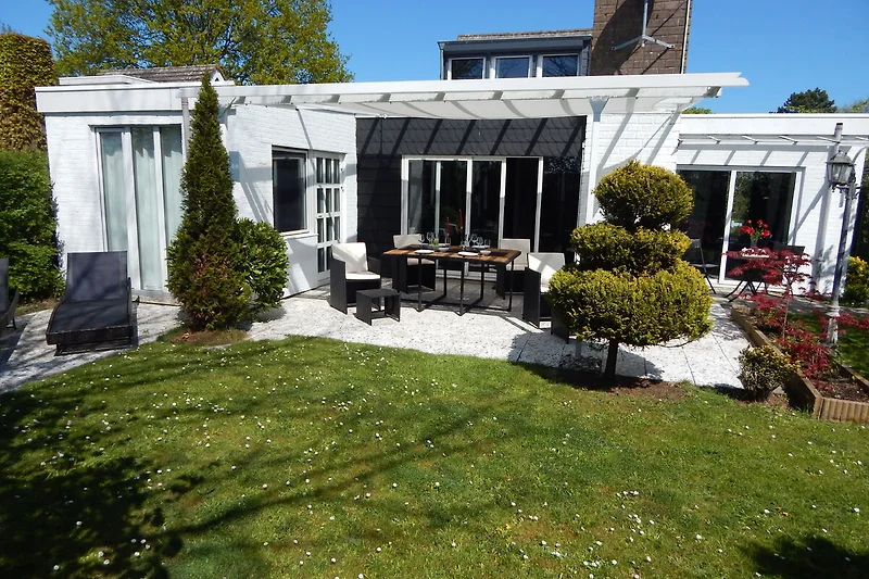 Großzügiger Garten mit Sitzgruppe, gepflegtem Rasen und schöner Villa.
