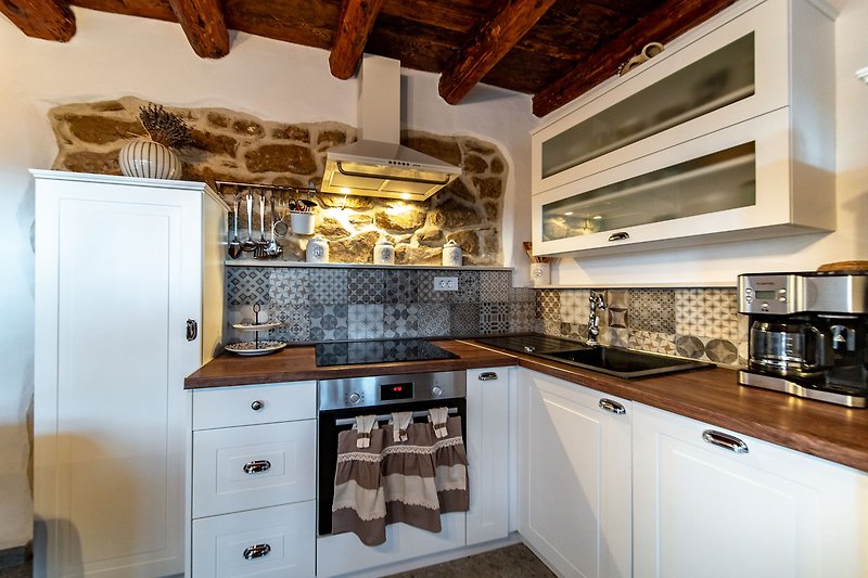Moderan kuhinjski prostor s drvenim elementima i kvalitetnim namještajem.