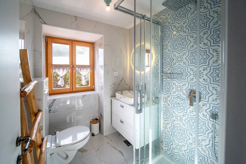 Moderan kupaonski prostor s elegantnim umivaonikom i svijetlim osvjetljenjem.