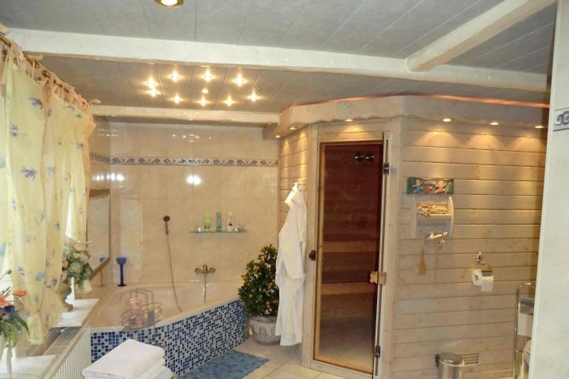 Badezimmer mit ebenerdiger Rainshower-Dusche und direktem Zugang zur Sauna