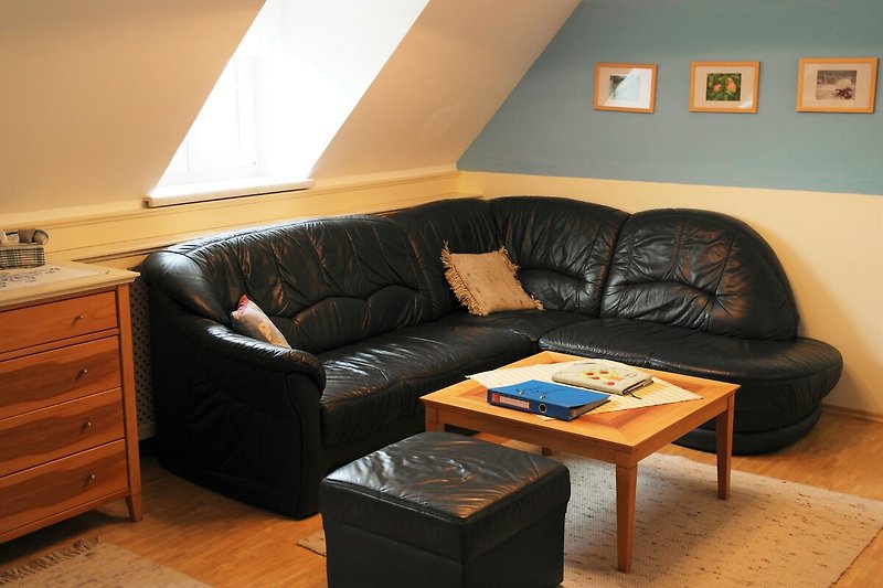 Gemütliches Wohnzimmer mit Holzmöbeln und bequemer Couch.