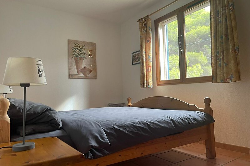 Gemütliches Schlafzimmer mit Holzbett und stilvoller Beleuchtung.