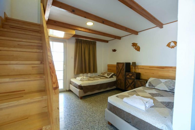 Gemütliches Schlafzimmer mit Holzmöbeln und großem Fenster.