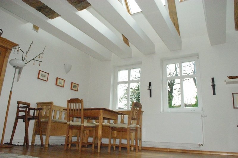 Espace de repas avec ouverture dans le plafond. La table est extensible pour 7 personnes.