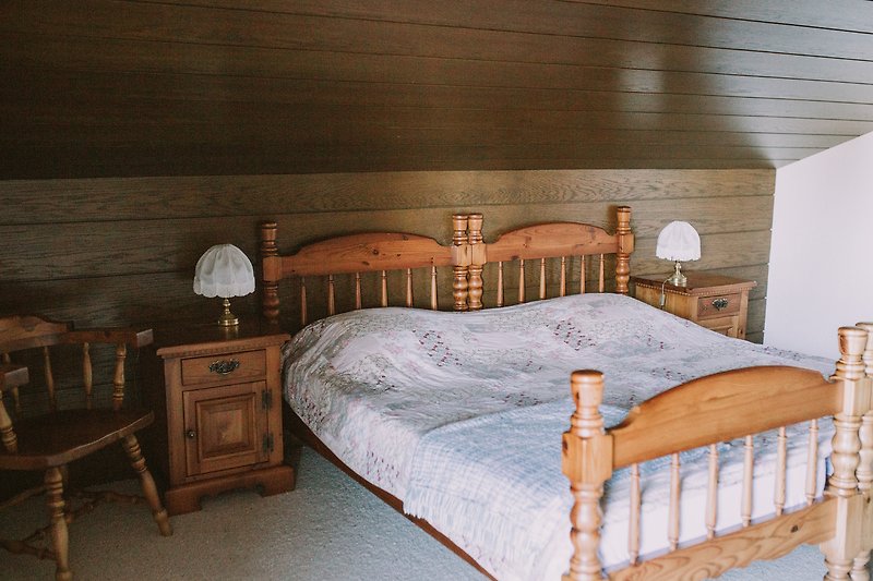 Gemütliches und Größen Schlafzimmer mit Holzmöbeln und stilvoller Beleuchtung.