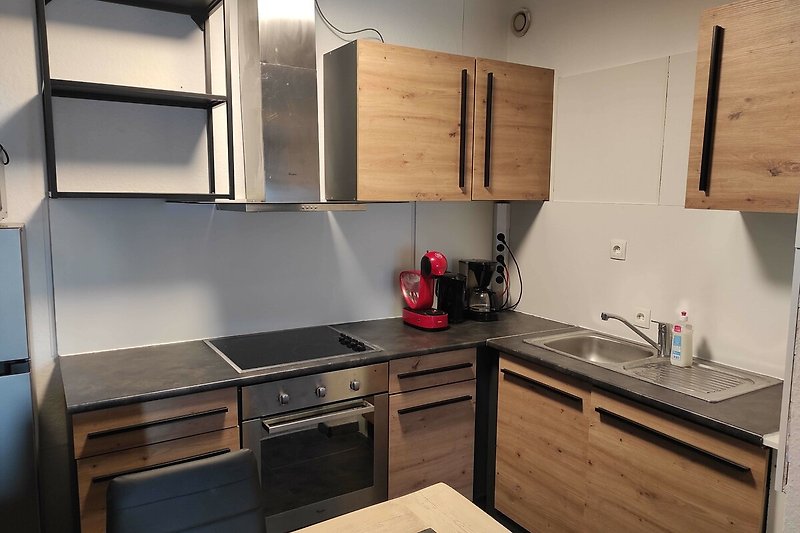 Moderne Küche mit Holzschrank, Arbeitsplatte und Spüle.