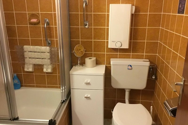 Gemütliches Badezimmer mit lila Akzenten, Spiegel und Toilette.