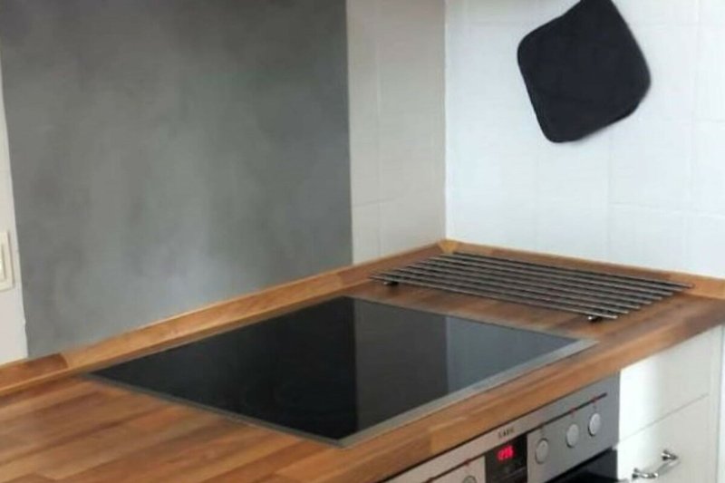Moderne Küche mit Holzoberflächen und hochwertigen Geräten.
