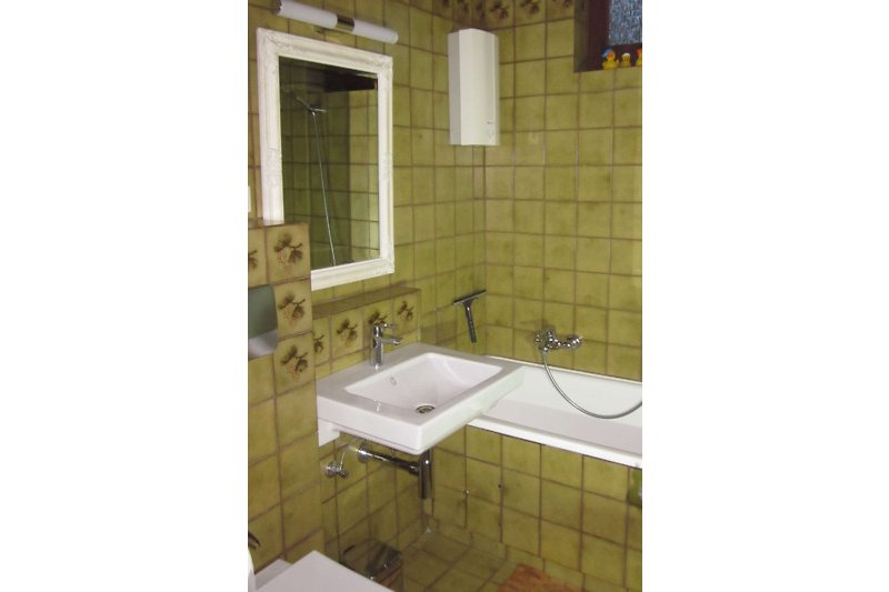 Schönes Badezimmer mit lila Akzenten und elegantem Spiegel.