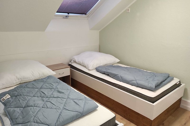 Gemütliches Schlafzimmer mit Holzbett und Fenster.