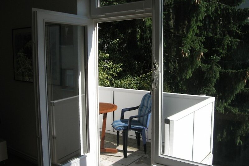 Moderne Außenansicht mit Holzverkleidung, Glasfenstern und schattigem Bereich.