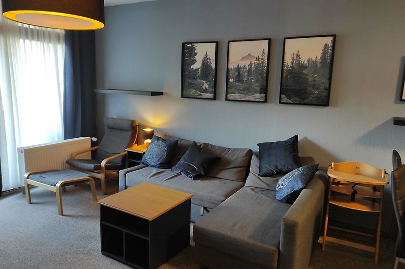 Stilvolles Wohnzimmer mit gelber Couch und Holzmöbeln.