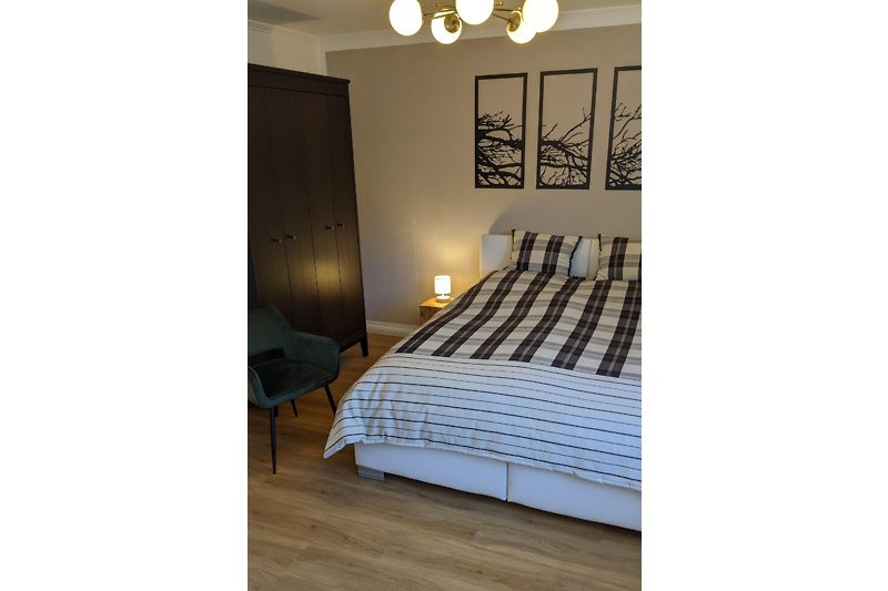 Komfortables Schlafzimmer mit Holzboden und stilvollem Design.