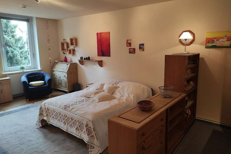 Stilvolles Schlafzimmer mit bequemem Bett und elegantem Holzmobiliar.