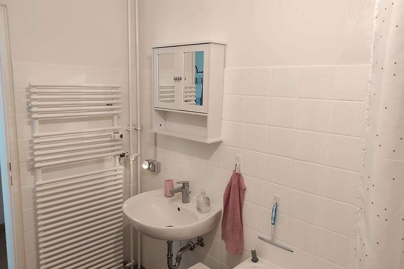 Gemütliches Badezimmer mit lila Wandfliesen und elegantem Waschbecken.