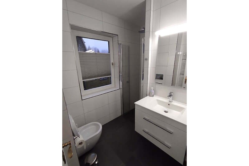Ein modernes Badezimmer mit lila Waschbecken und elegantem Design.