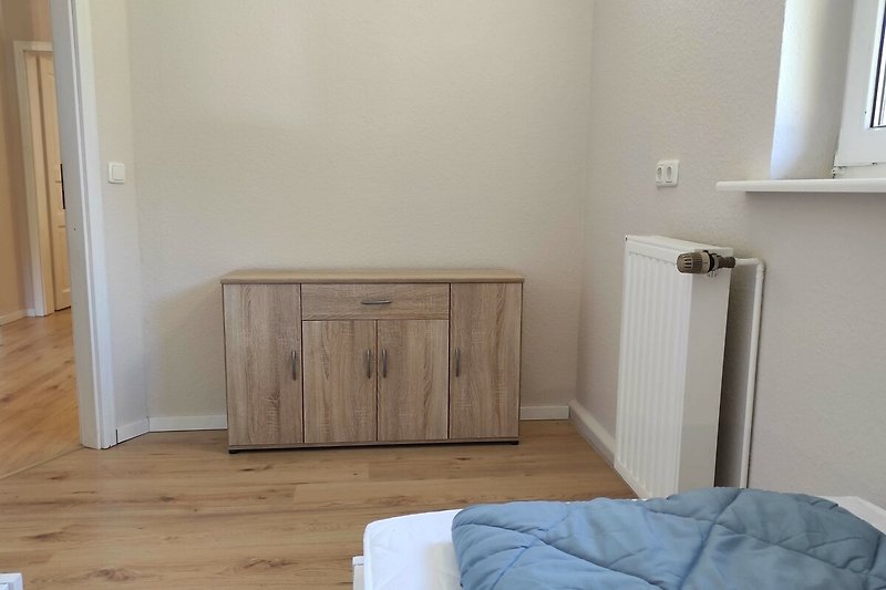 Einladendes Schlafzimmer mit Holzmöbeln und gemütlichem Bett.